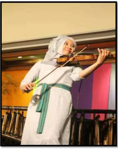 Gambar 4.6 Shelma, biasa memegang alat musik biola, angklung dan gambang bambu 