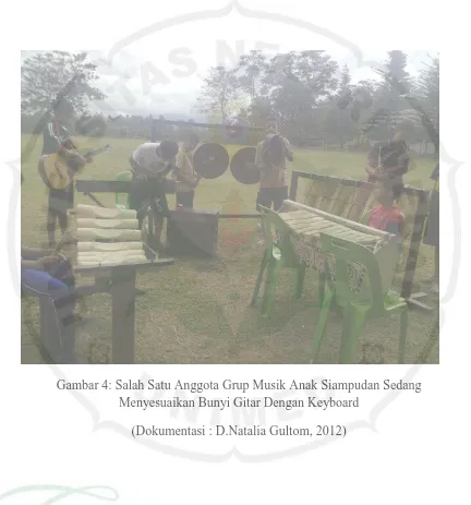 Gambar 4: Salah Satu Anggota Grup Musik Anak Siampudan Sedang Menyesuaikan Bunyi Gitar Dengan Keyboard 