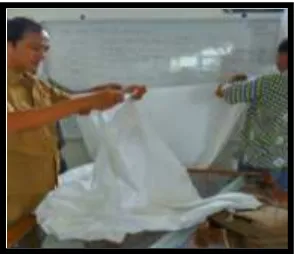 Gambar VI: peserta didik dibantu guru batik dalam menyiapkan kain mori. 