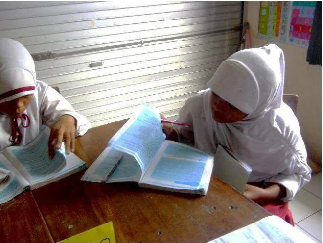 Gambar 9. Siswa sedang membaca buku untuk mencari jawaban atas tugasnya (Kamis, 28 Mei 2015) 
