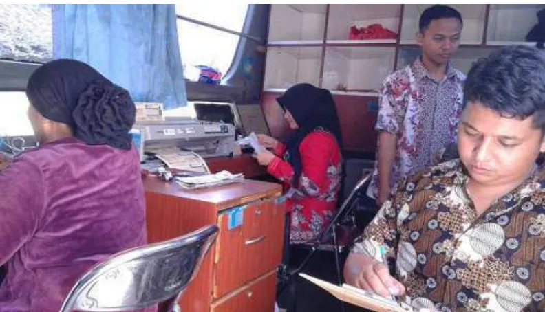 Gambar 1.Petugas Pelaksana sedang mengerjakan tugas dalam bus layanan samsat keliling di Kecamatan Secanggang (Sumber : Observasi 3 Maret 2016)
