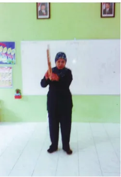 Gambar 5. Guru sedang memberi contoh memainkan alat musik angklung 