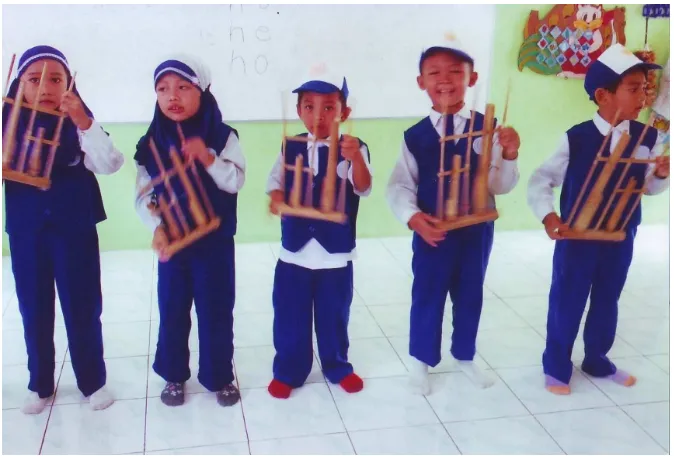 Gambar : 6. anak-anak sedang  memainkan alat musik  angklung  