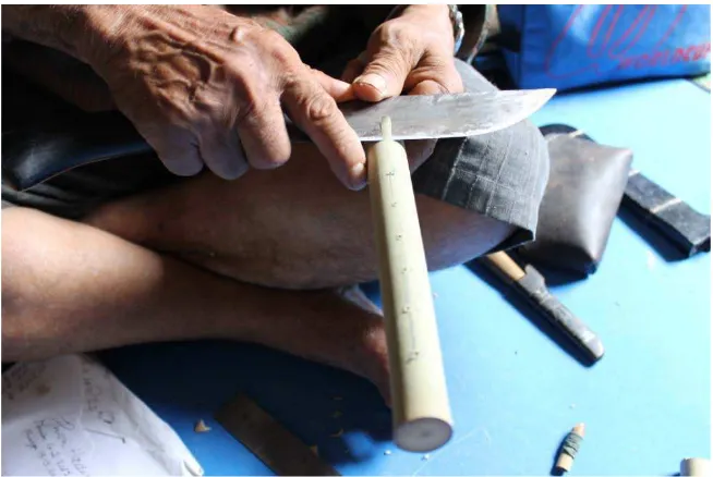 Gambar III.27. Pengupasan kulit bambu dengan pisau belati 