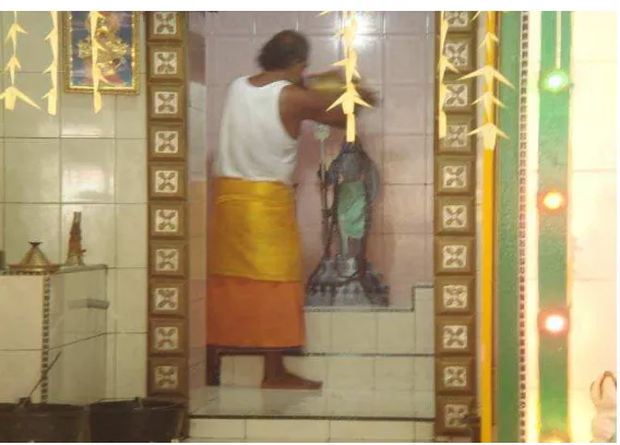Gambar 3.11. Seorang pendeta sedang melakukan abhisegammemandikan arca Dewa dengan susu dan aneka bunga