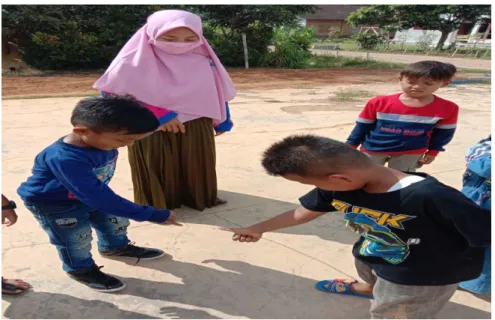 Gambar  3.  Anak  sedang  melakukan  suit  untuk  menentukan  siapa  yang  akan  menjadi  penjaga  dan  sebelum  memulai  kegiatan  Permainan Tradisional Gobag Sodor di halaman TK Pertiwi 2 Desa  Sidodadi Kecamatan Pekalongan Lampung Timur