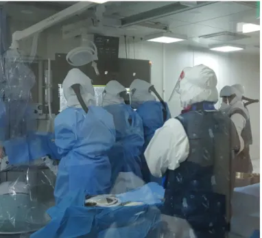 Fig. 3. Scene at the time of procedure. Medical staffs wore level D personal protective equipment including 2  pairs of surgical gloves, N95 mask, goggle, face shield, protective suit, leg covers, and sterile surgical gown.