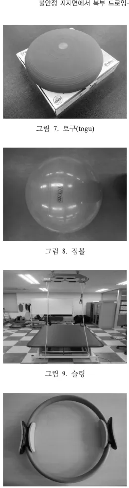 그림  7.  토구(togu) 그림 8.  짐볼  그림 9.  슬링  그림 10.  필라테스  써클     4) 운동방법 교각운동  시  복부  드로잉-인  방법을  사전에  교육하고 숙지시킨 후 복부 드로잉-인을 동반한 교각운동을 불안정 지지면에서 짐볼,  슬링,  필라테스 써클을 이용하여 실시하였다(그림 11).운동 순서로는 첫째,  사용도구 없이 교각운동,  둘째,  짐볼을 이용한 교각운동,  셋째,  슬링을 이용한 교각운동,  넷째,  필라테스 써