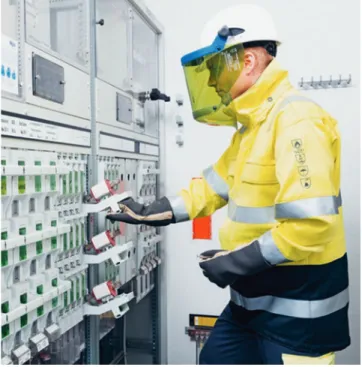 Fig. 4.2  Electrician equipped with PPE: Helmet, arc-flash resistant visor, insulating gloves, fire-  resistant jacket