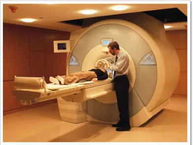 圖  2-6    功能性核磁共振造影（fMRI）的使用情形  圖中的研究人員正在替受試者安放固定頭部位置的裝置 