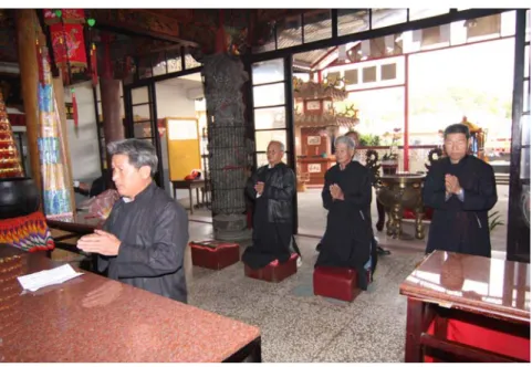 圖 29  在三聖宮內舉行之告神儀式    攝影者：張永鵬    花鼓隊前導的車隊出宮後，穿過後龍溪上的客屬大橋，再經台 72 線往中心埔五穀 宮的方向前行。中心埔五穀宮是五聯庄的主廟，廟裡主祀五穀大帝，而五聯庄共同信仰 的媽祖就祀奉在此。一進入宮前的廣場，五穀宮立刻鳴砲、敲響鐘鼓迎接神轎的到來， 廣場上已安置有車輛三部（香旗、芭蕉扇等已分別放置在三部車上）及神轎兩頂在宮的 正門前，另在兩神轎的中央還擺上了一個香案，香案上放了兩疊金、兩串長錢、五盤糖 果。  進入宮內，在場人等先向五穀大帝上香，再轉往左殿的