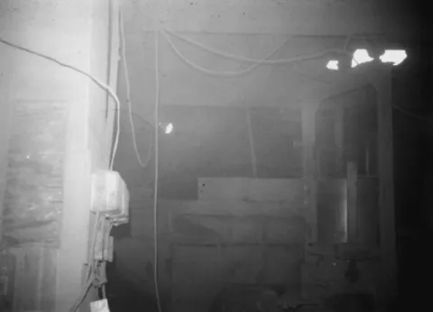 Figure 1. Workplace full of fumes in a ferromanganese smelter. Because the local ventilation system was out of order, the surfaces of the walls and electricity meters were covered with a thick layer of dust