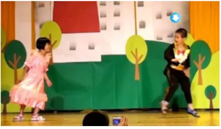 圖 5-4-7  劇照：幼兒提醒同儕該退場了  同學該退場了。圖 5-4-8 是幼兒謝幕時相互協調演員列隊的等候線，先謝幕的新 媽媽和兩個姊姊起初站在上舞臺第一條膠帶線，不知何故三人忽然又前進，選擇  圖 5-4-8  劇照：幼兒（箭頭所指）協調謝幕時，演員在上舞臺列隊的等候線  站在第二條線上，其後謝幕的灰姑娘與她們站在同一列時，向新媽媽表示此時應 該是站在後面那條線上。但由於新媽媽沒有給予換位置的回應，下一組謝幕演員