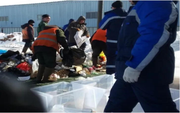 Figure 2. Nazarbayev University laboratory workers sorting the garbage into different  categories with the landfill workers (own photo)
