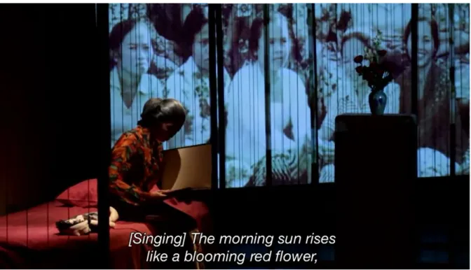 Figure 2. On the left side of the stage where her bed is located, Suhartini reminisces  on her days as an activist while perusing an album, with pictures of the Gerwani  women flashed on the screen behind her and the song Salam Harapan playing in the  back